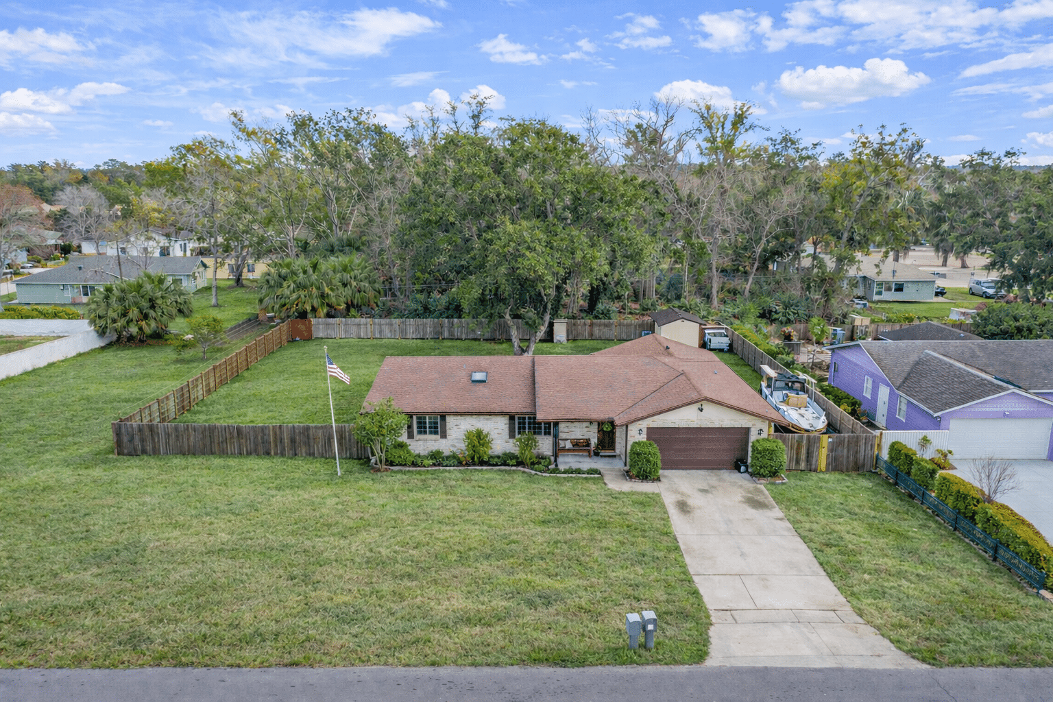 Aerial view of a charming single-family home for sale in a suburban neighborhood.