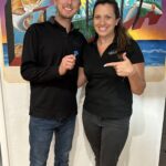 Hayley Vezza and partner at Local Living Real Estate holding a blue dart