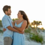 Couple embracing on a beach at sunset, possibly Hayley Vezza and partner.