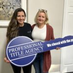 Hayley Vezza and colleague with Professional Title Agency key