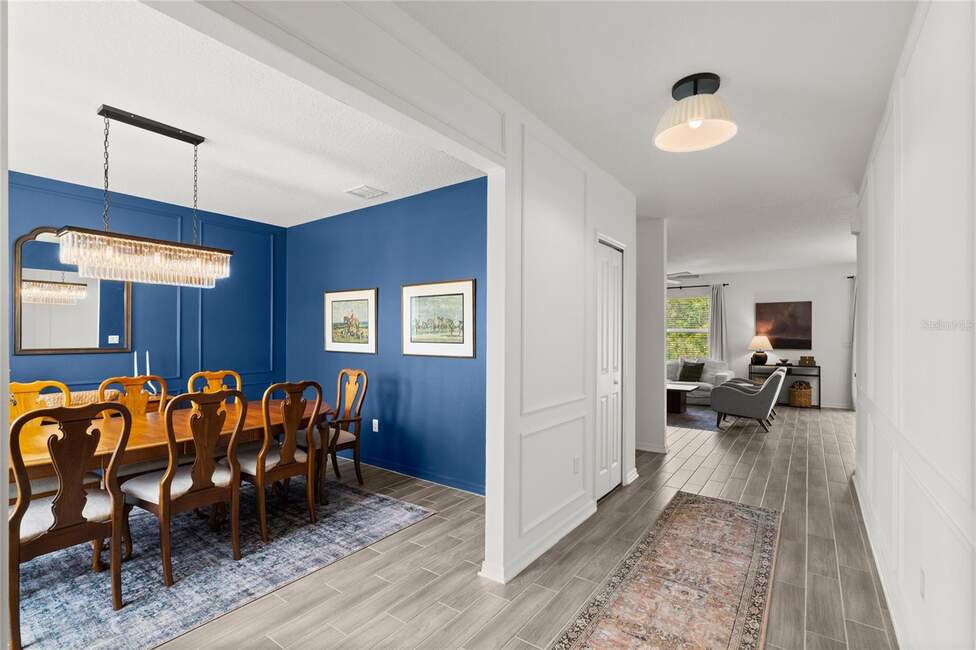 Elegant dining room with blue walls and a chandelier at 2516 Hoptree Ln, Edgewater, FL