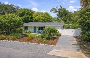 Charming single-story home at 115 Orange Avenue, Edgewater, FL with a lush garden and driveway.