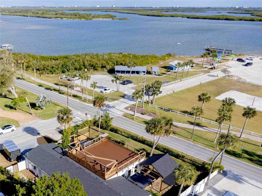 Aerial view of 500 S Riverside Dr, Edgewater, FL with waterfront, deck, and buildings