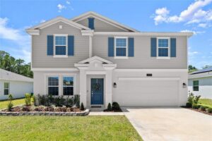 Front exterior of 2516 Hoptree Ln, Edgewater, FL 32141, a two-story home with gray siding and blue shutters.