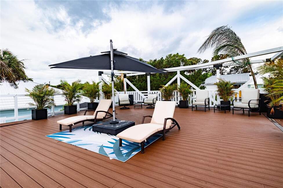 Rooftop deck with lounge chairs and umbrella at 500 S Riverside Dr, Edgewater, FL